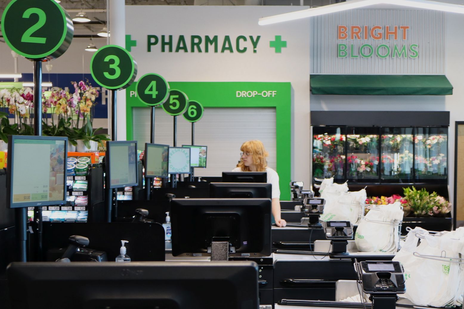 The calm before the storm. A cashier mans her station minutes before the doors opened at FreshTake. The new grocery store opened for business on January 20.