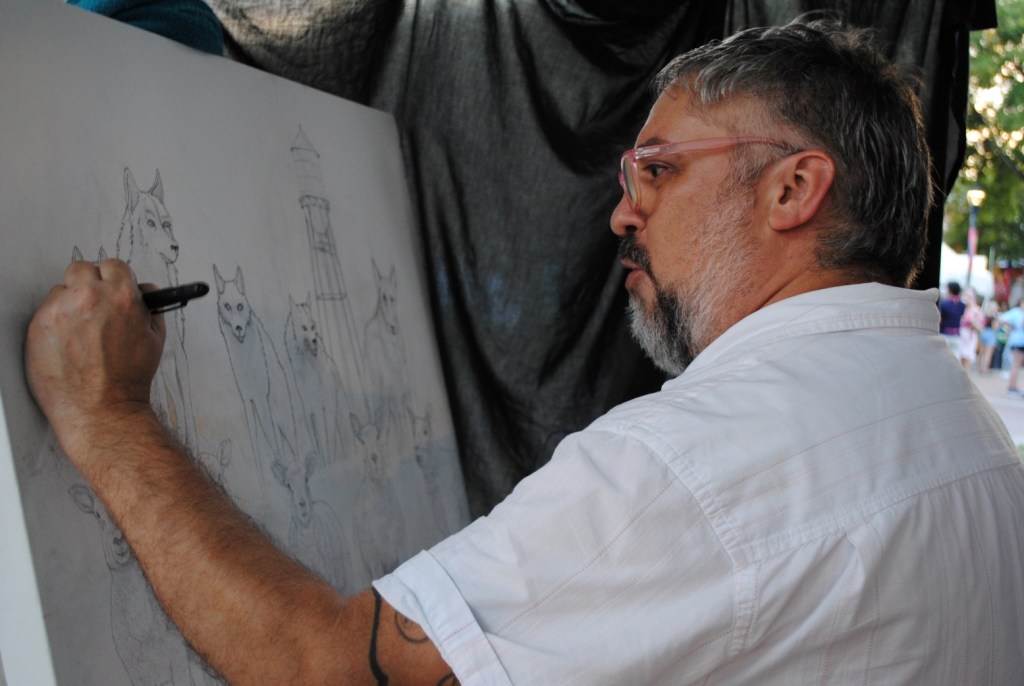 Artist Blaine Prescott works on his Artzilla Live Painting submission at the 2024 Arts In the Heart of Augusta Festival.