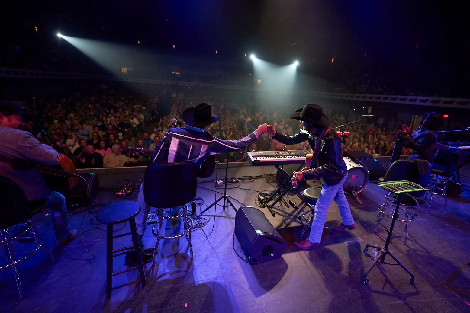 Chris Janson and Zach Top exchange a fist bump during the 2024 Guitar Pull Concert.